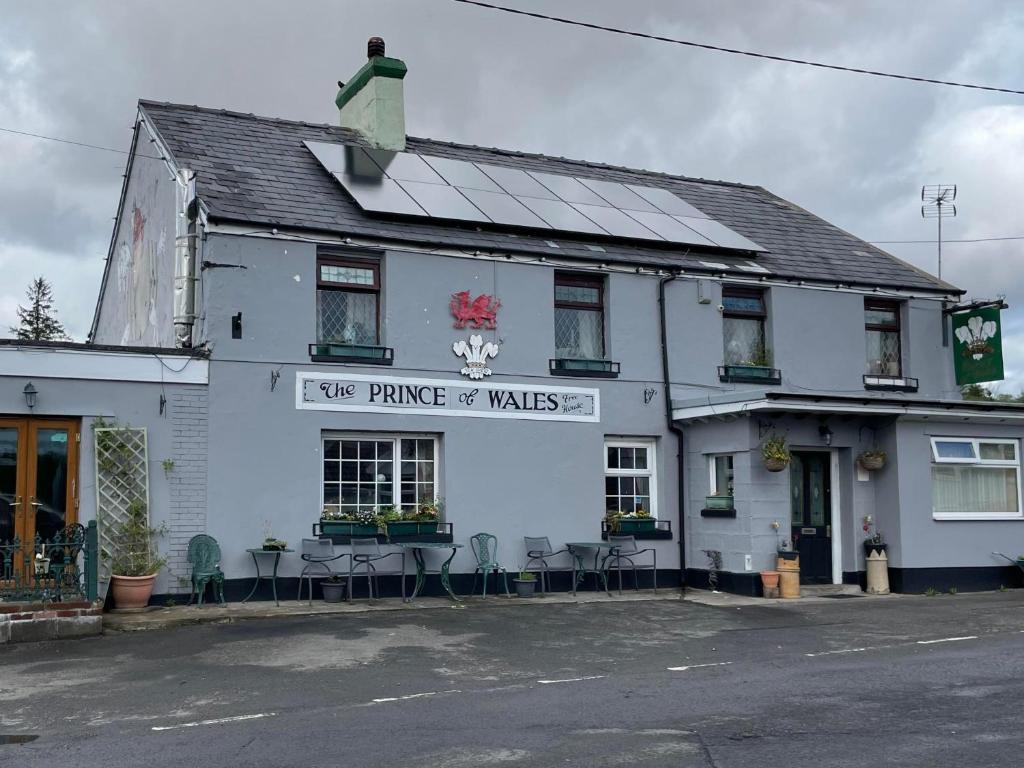 um edifício branco com um sinal que lê cinco promessas de passeios em Prince of Wales inn em Caerphilly
