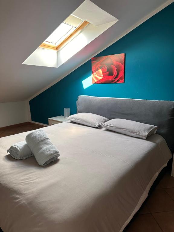 1 dormitorio con 1 cama blanca grande y pared azul en Tra Stadio e Storia - Fronte Allianz Stadium Juventus, en Venaria Reale