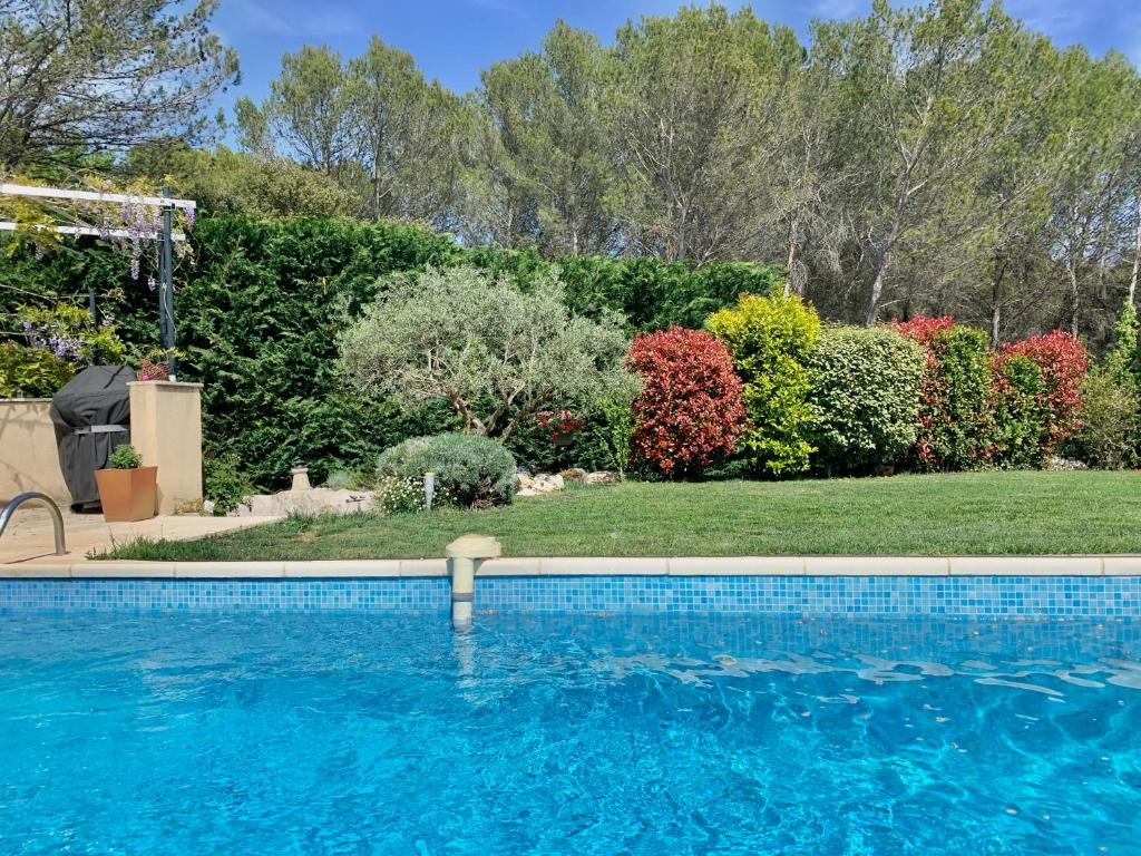 a swimming pool in front of a yard at Villa du Soleil en Provence sur le Domaine du Golf de Pont Royal in Mallemort