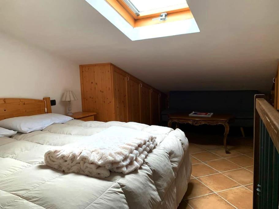 [Free Parking] - Casa in Montagna في ريفيسوندولي: غرفة نوم بسريرين بيض مع منور