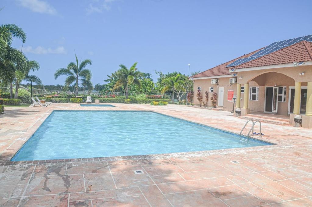 a large swimming pool in a yard with a house at Twin Peak Cottage in Mammee Bay
