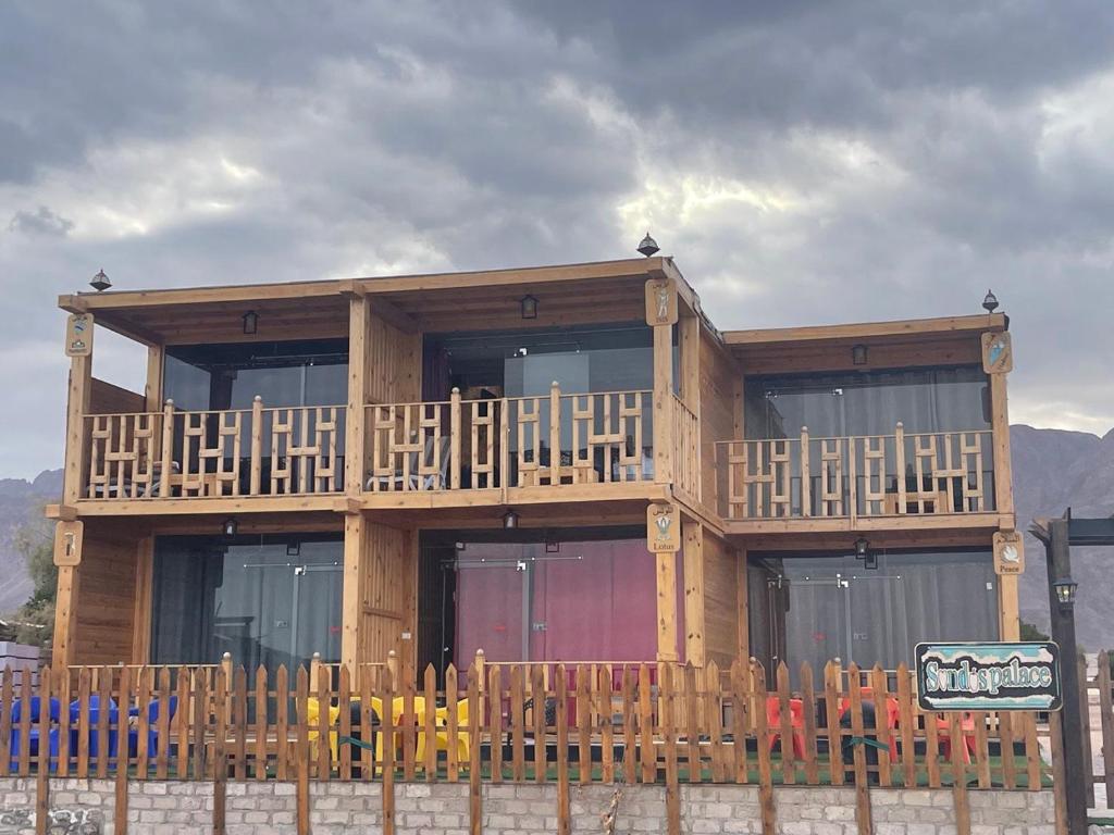 a wooden building with a balcony with a lot of windows at Sondos Camp in Nuweiba‘ el Muzeinah