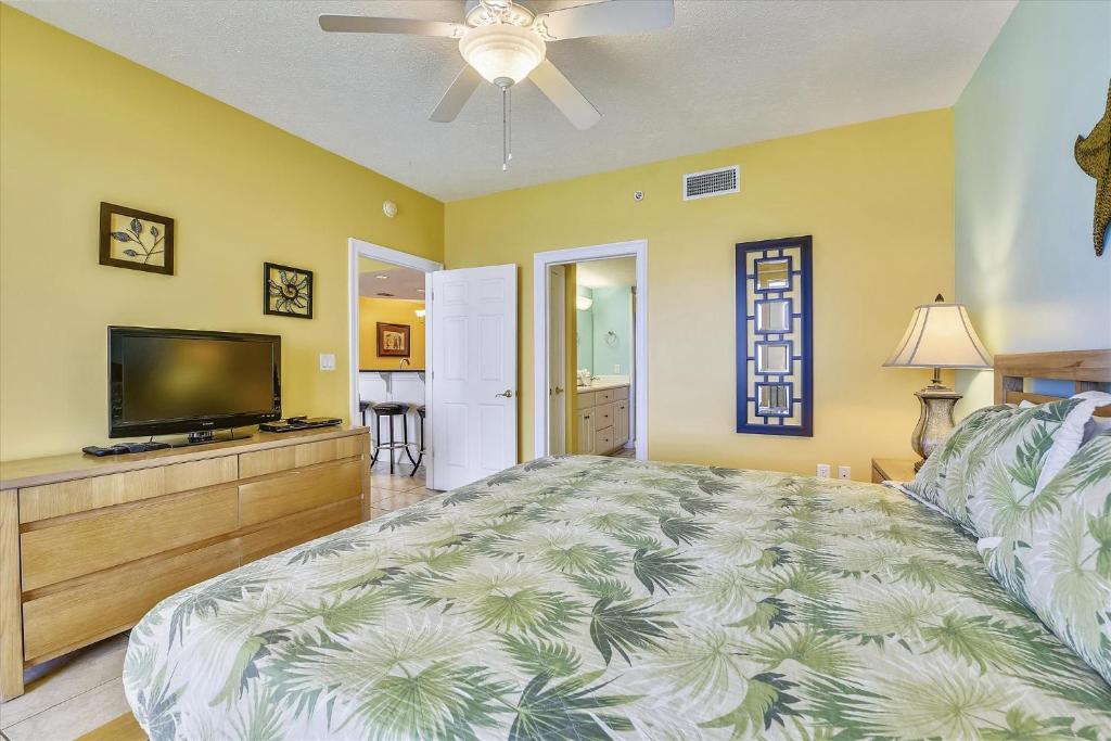 ein Schlafzimmer mit einem großen Bett und einem Flachbild-TV in der Unterkunft Treasure Island 1102 in Panama City Beach