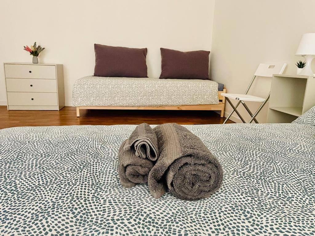 een bed met een stapel handdoeken erop bij N'amuri Guest House in Siracusa