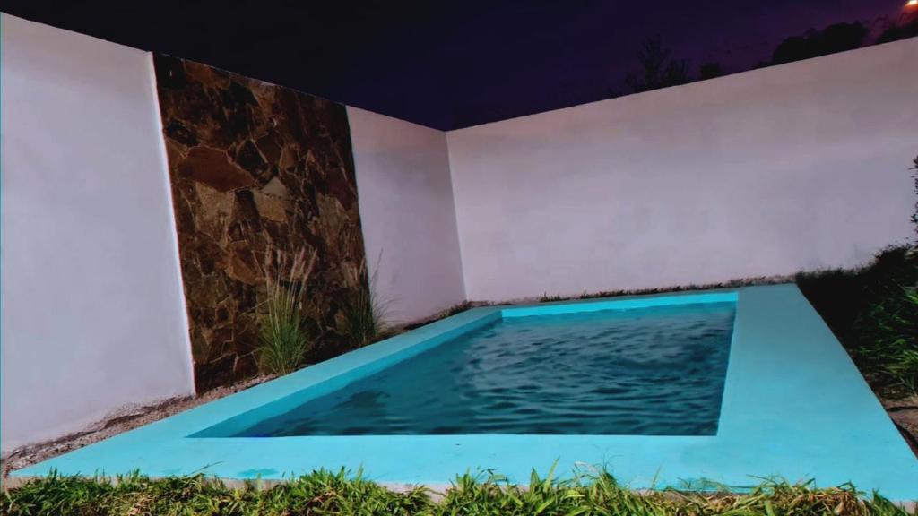 una piscina en el patio trasero de una casa por la noche en La Cabrera Salta en Salta