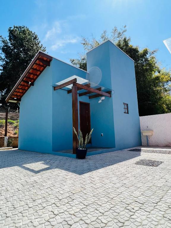 a blue house with a potted plant in front of it at Chalé Mantiqueira - Cunha in Cunha