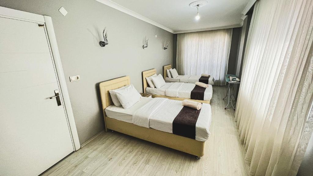 twee bedden in een kleine kamer met een raam bij Heaven Family Apartments in Trabzon