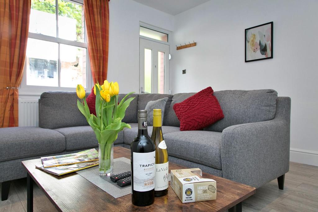 a living room with a couch and a table with two bottles of wine at Finest Retreats - Brook View in Colwyn Bay