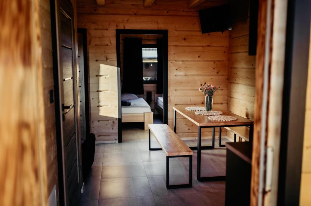 ein kleines Zimmer mit einem Tisch und einem Schlafzimmer in der Unterkunft Sosnowy Zakątek in Józefów