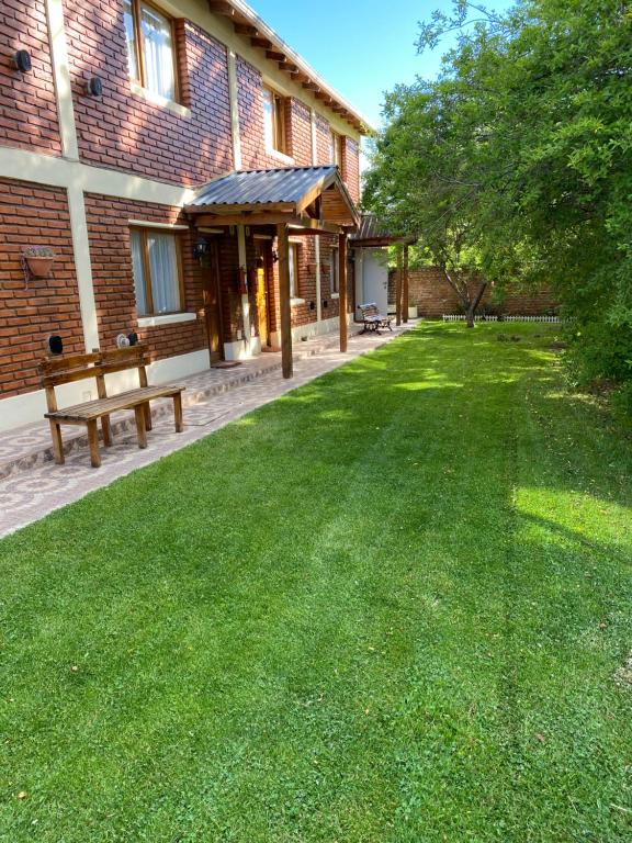 a yard with a bench in front of a building at Departamentos Ailen in Esquel