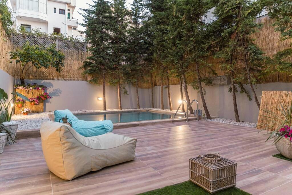 une terrasse avec une piscine, un canapé et une chaise dans l'établissement G&M Luxury Residence with pool, à La Canée