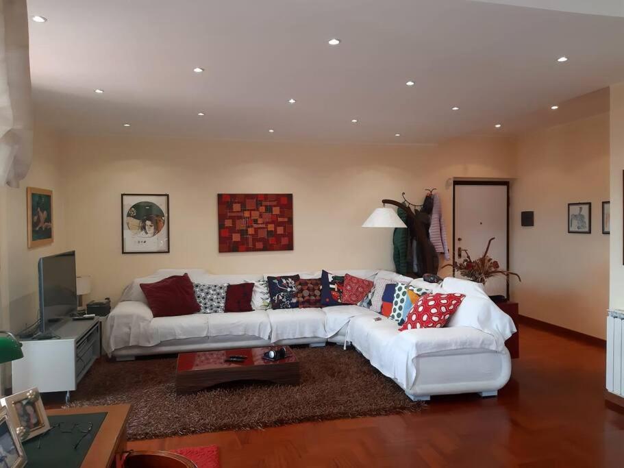 ein Wohnzimmer mit einer weißen Couch mit Kissen in der Unterkunft Dilly Home Holiday-Casa vacanze in Aci Castello