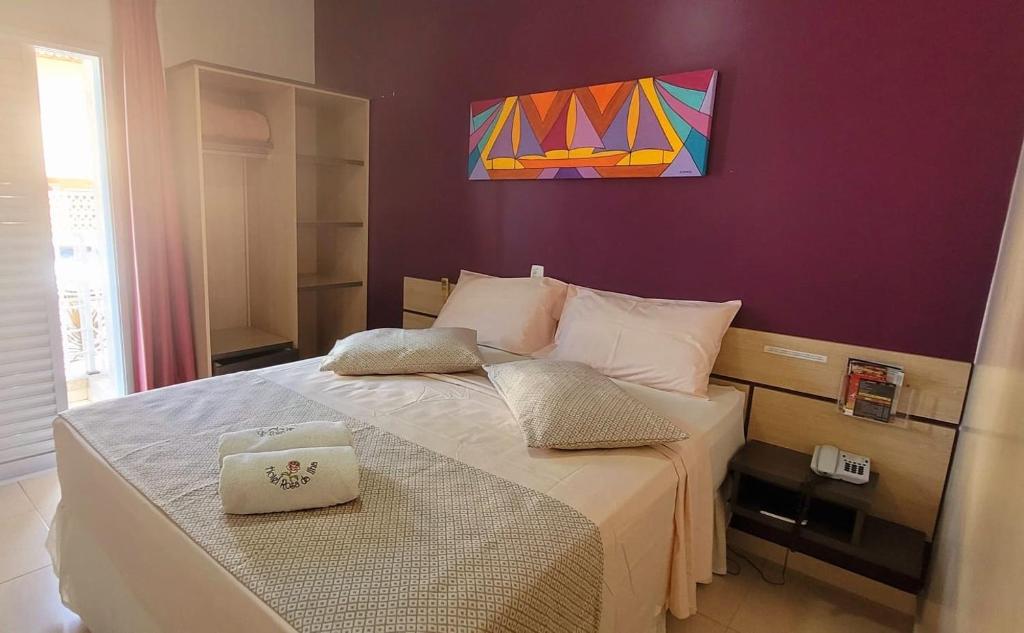 um quarto com uma cama com um quadro na parede em Hotel Rosa da Ilha - Pertinho do Mar com piscina no Guarujá