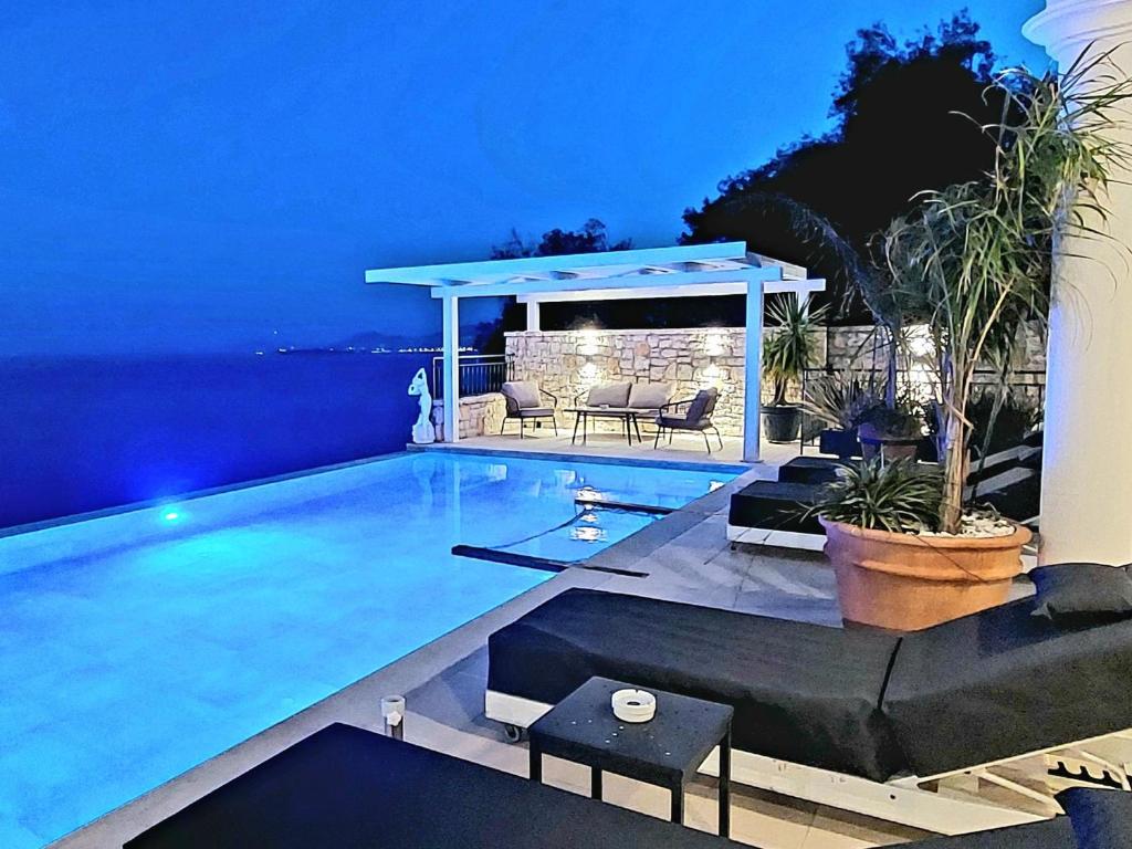 a swimming pool in the middle of a backyard at night at Aquamarine Villa in Agní