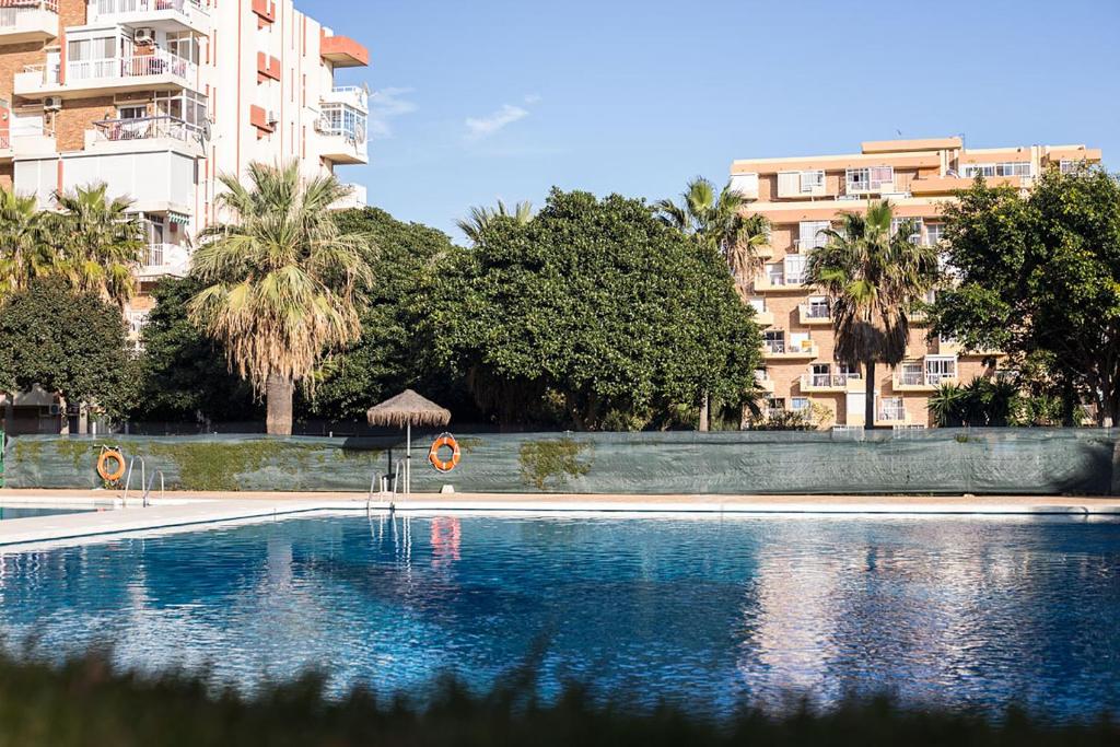 ベナルマデナにあるPrecioso apartamento Benalmadena!!!の建物の前に傘付きのスイミングプール