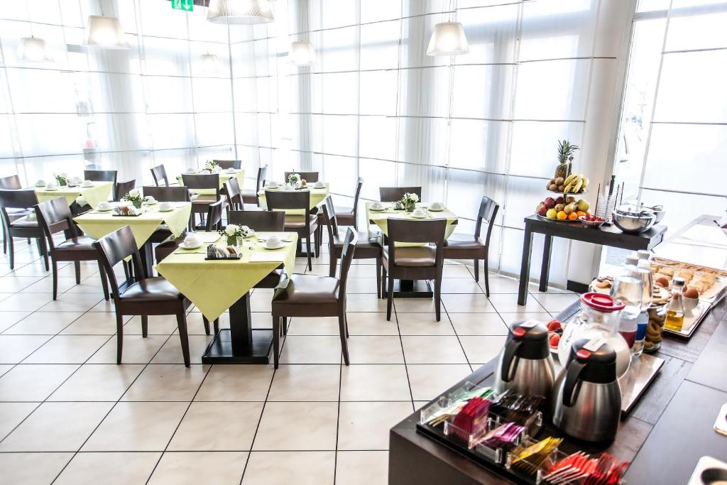 a dining room with tables and chairs in a restaurant at Hotel Mosaico & Residence in Ravenna