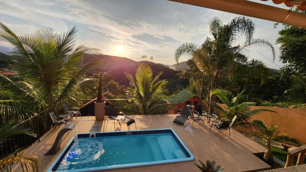 a swimming pool on a deck with a view of the mountains at Suíte Sunset in Miguel Pereira