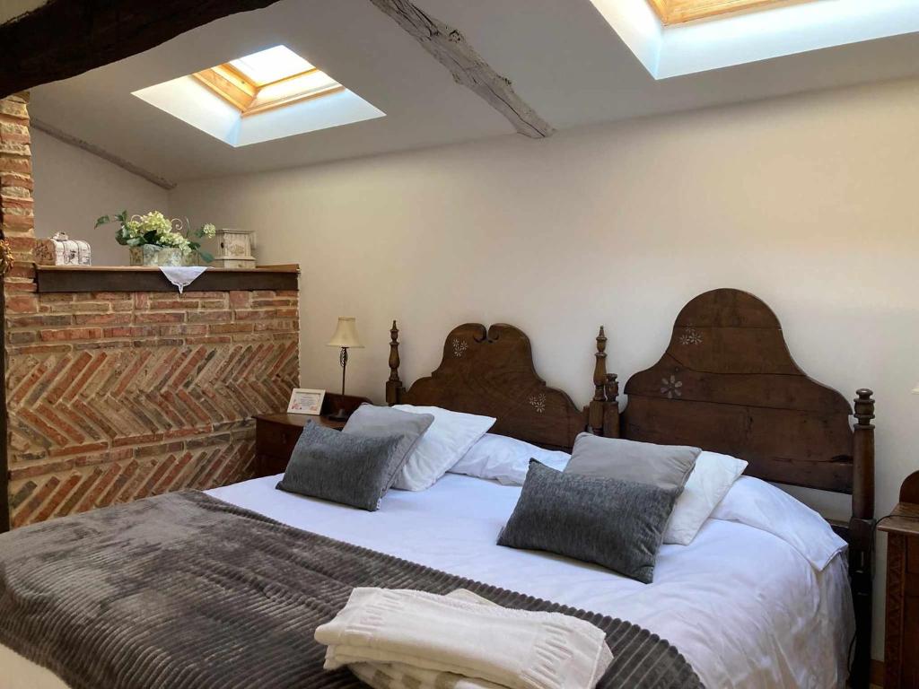 um quarto com uma cama grande e 2 almofadas em Casa parejas La casa de Quintanilla 1 em Quintanilla las Torres