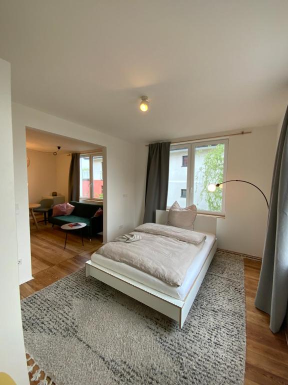 a white bedroom with a bed and a living room at steenkampstudios GRANNS' SUITE in Hamburg