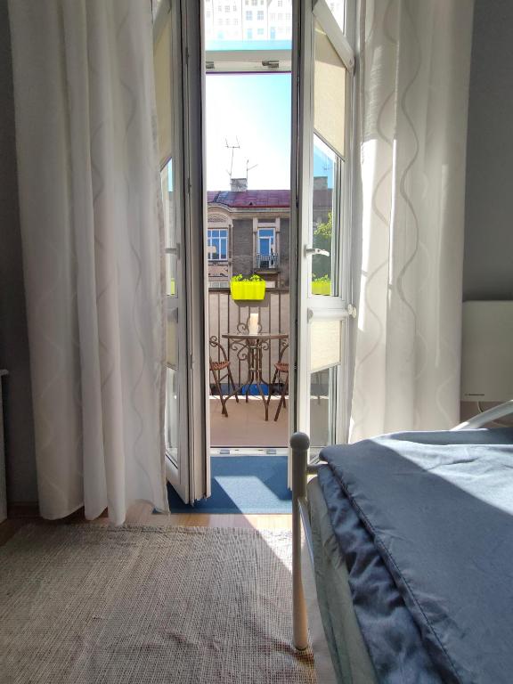 um quarto com uma cama e vista para uma varanda em LittleRoom em Lublin