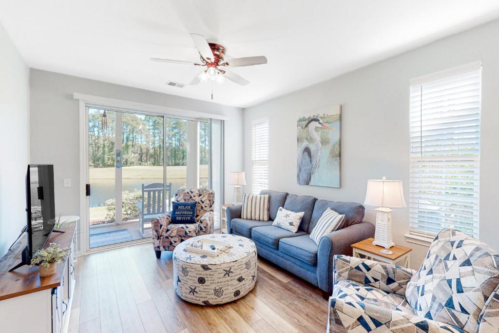 a living room with a blue couch and chairs at Sweet Retreat in Sunset Beach