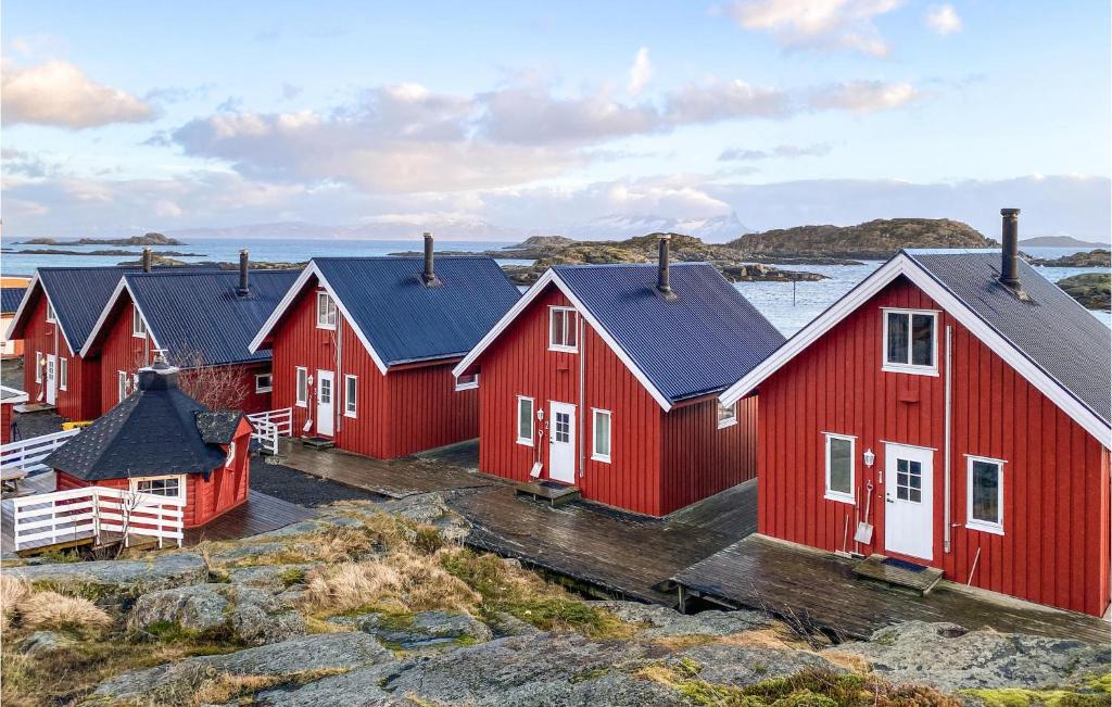 una fila de casas rojas en una isla rocosa en Beautiful Home In Offersy With Kitchen, en Offersøy