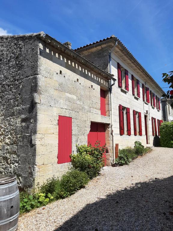 un bâtiment en briques avec des portes et des fenêtres rouges dans l'établissement Maison Rouge, à Montagne