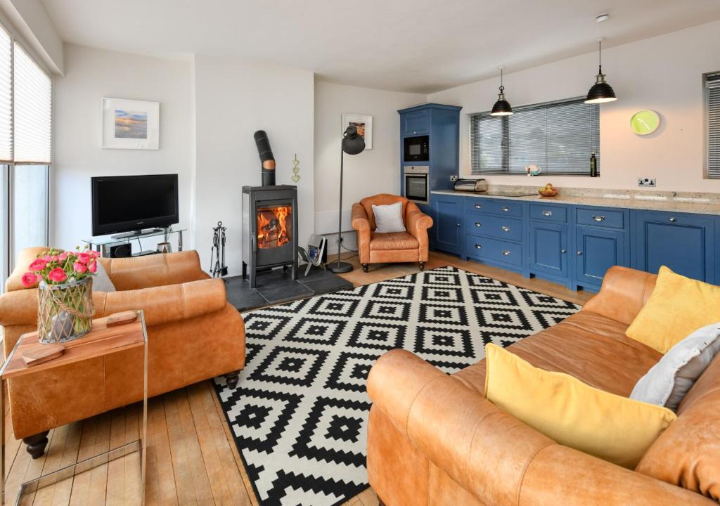 a living room with two couches and a fireplace at 20 Cae Du in Abersoch