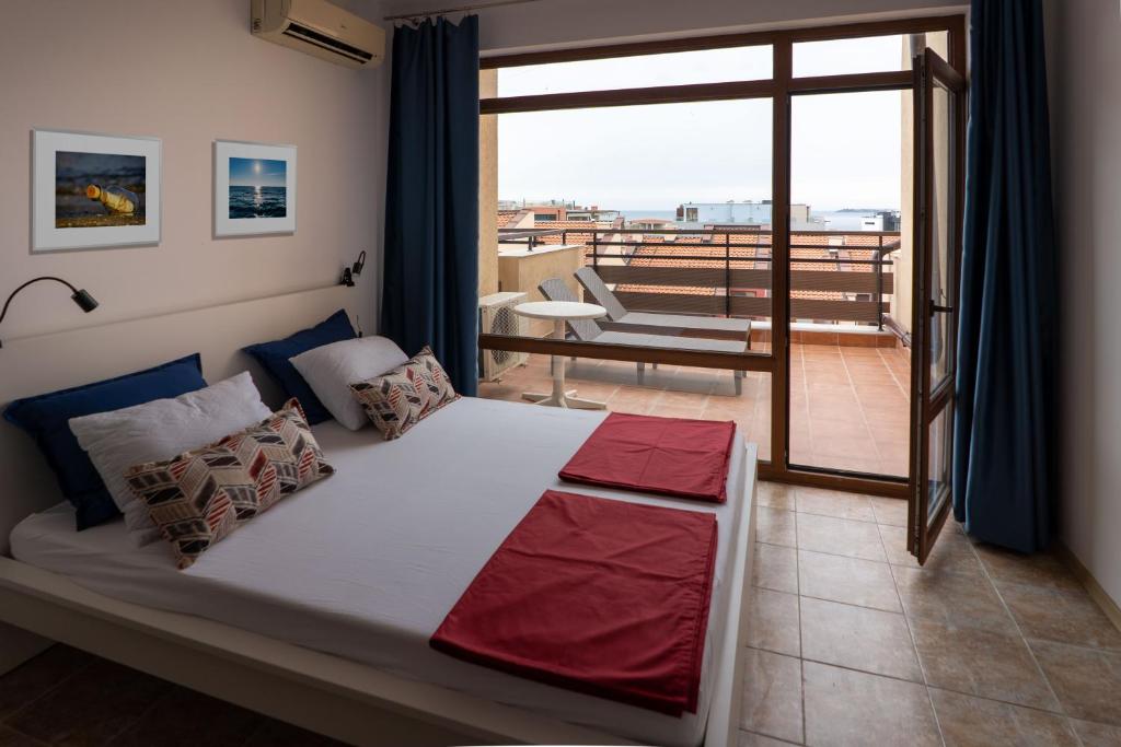 ein Schlafzimmer mit einem großen Bett und einem Balkon in der Unterkunft Lighthouse in Sweti Wlas