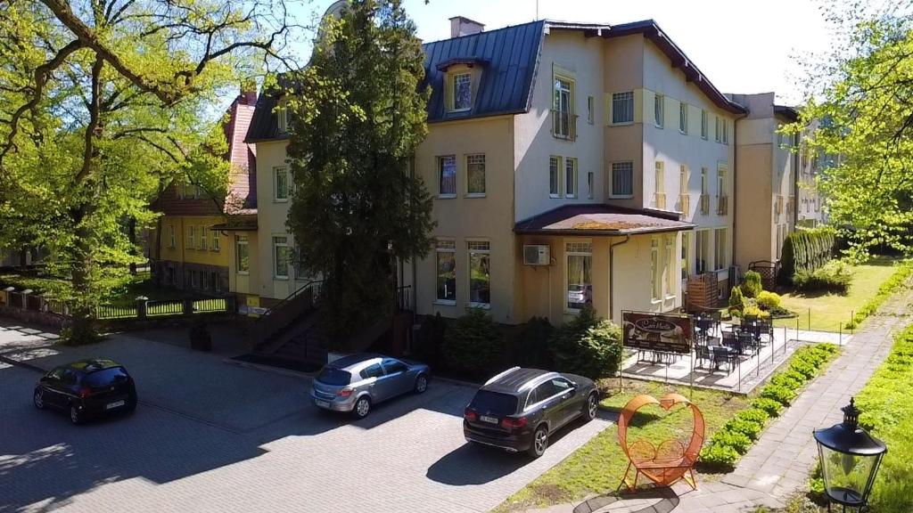 a large house with cars parked in front of it at Marta Medical in Połczyn-Zdrój