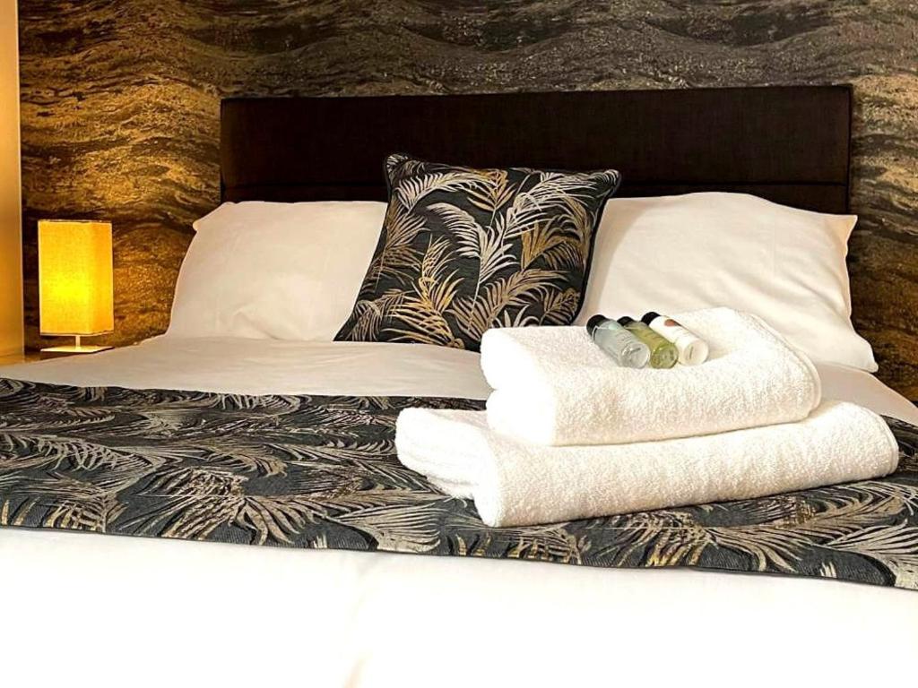 a bed with two towels and two dolls on it at The Corner Rooms at The Black Horse Inn in Spennymoor
