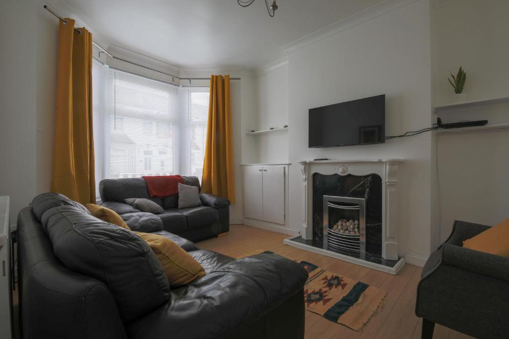 ein Wohnzimmer mit einem Sofa und einem Kamin in der Unterkunft A Perfect 3BD Home away from Home Canton Cardiff in Cardiff