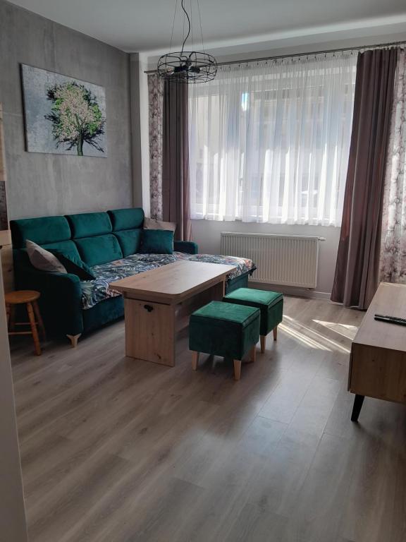 a living room with a couch and a table at Apartament Królewiecka 54b/26 in Mrągowo
