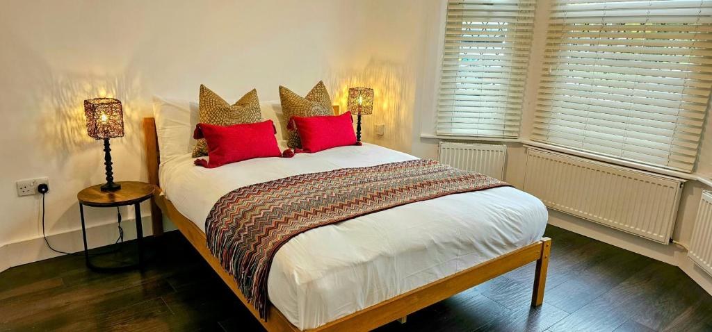 una camera da letto con un grande letto con cuscini rossi di Victorian Property a Londra