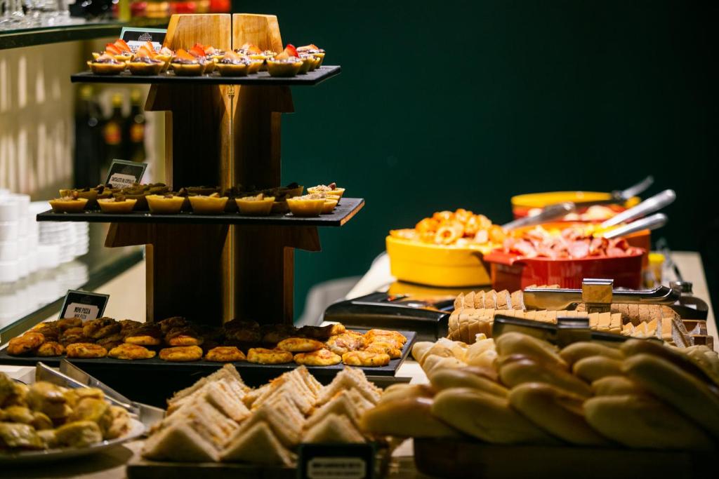a buffet filled with different types of pastries and desserts at Mercure Belem Boulevard in Belém