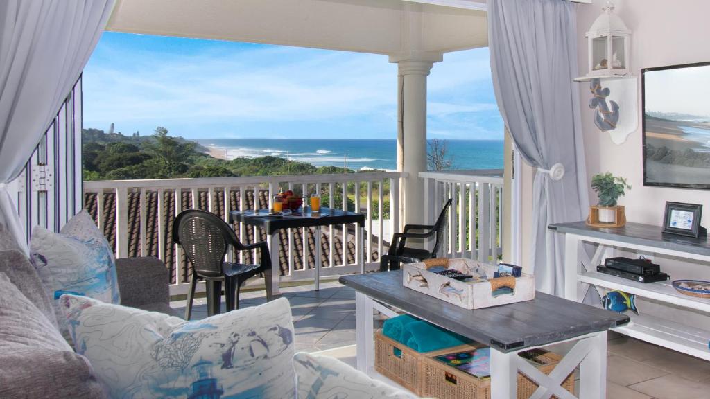 a living room with a balcony with a view of the ocean at At 4 Umzumbe Beach Apartment, Mangrove Beach Estate in Melville