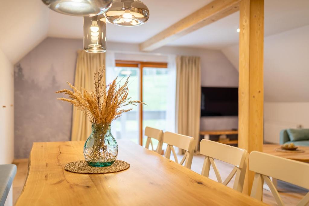 eine Blumenvase auf einem Holztisch in der Unterkunft Apartmány U 3 Zbujů in Malenovice