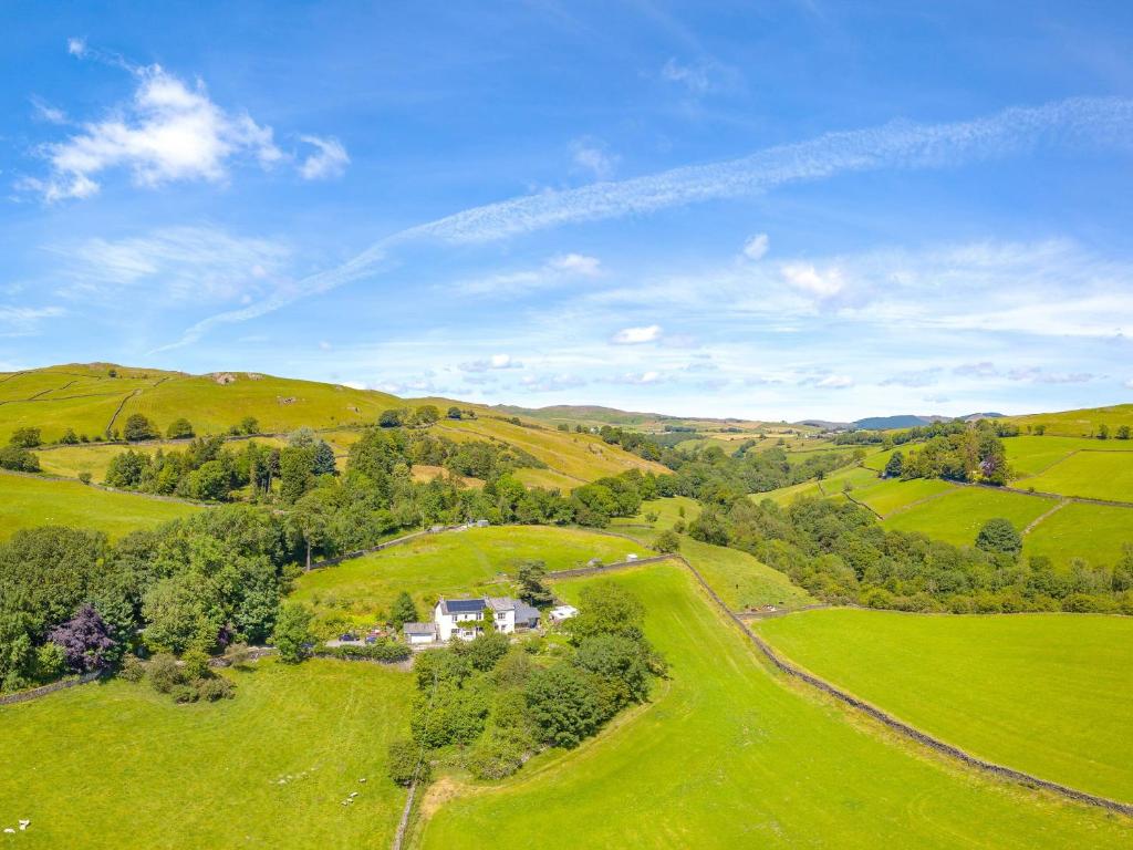 una vista aérea de una casa en un campo verde en Saul Hill, en Lake District National Park