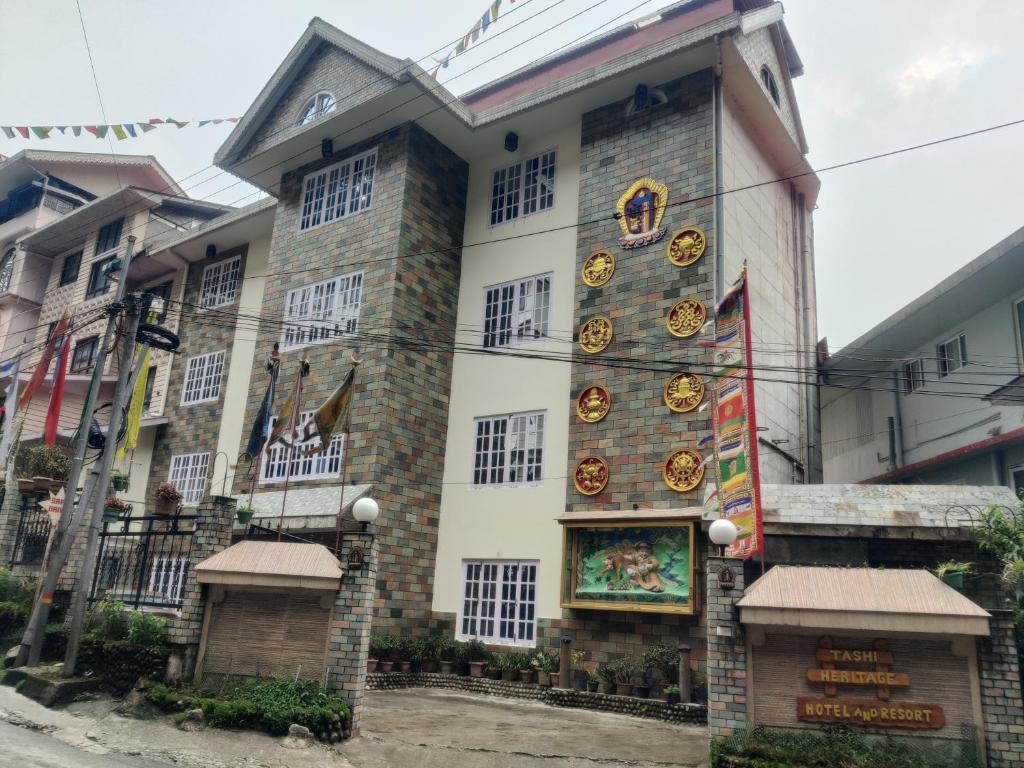 a building with a sign on the side of it at Keswani Group Tashi Heritage Hotel & Resort in Gangtok