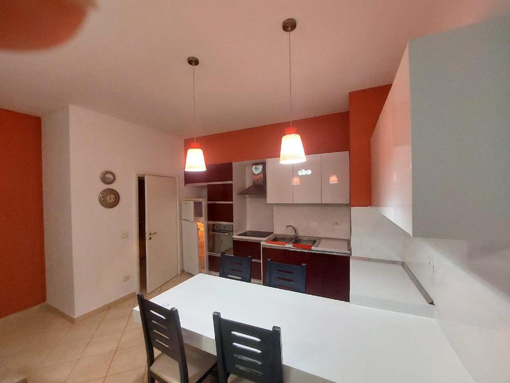 a kitchen with two chairs and a table in a room at Redsun City Center Apartment in Vlorë