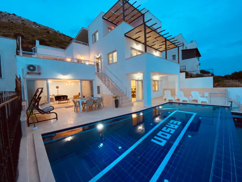 a villa with a swimming pool in front of a house at AYRİS VILLAS & HOUSES in Bodrum City