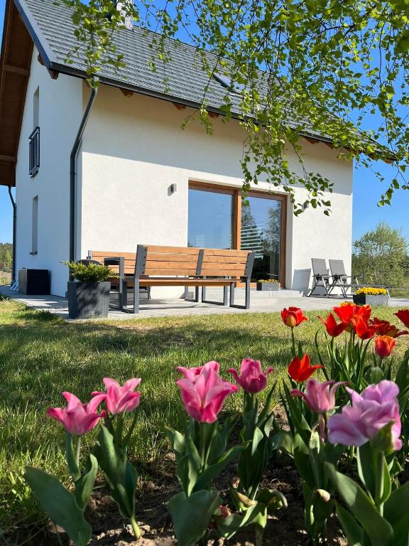 un banco frente a una casa con flores en Dom na Kaszubach &quot;White House&quot; całoroczny na wyłączność, en Stężyca