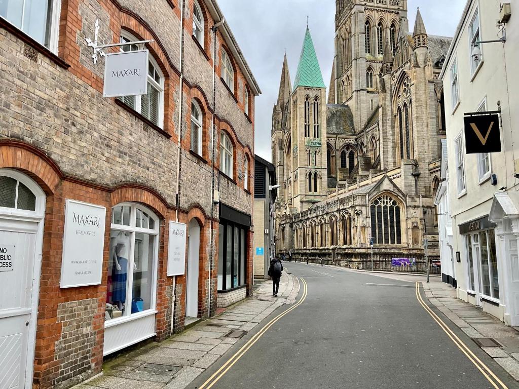 une personne marchant dans une rue en face d'une église dans l'établissement 8, St Marys , Private Double Ensuite Room - Room Only- Truro, à Truro