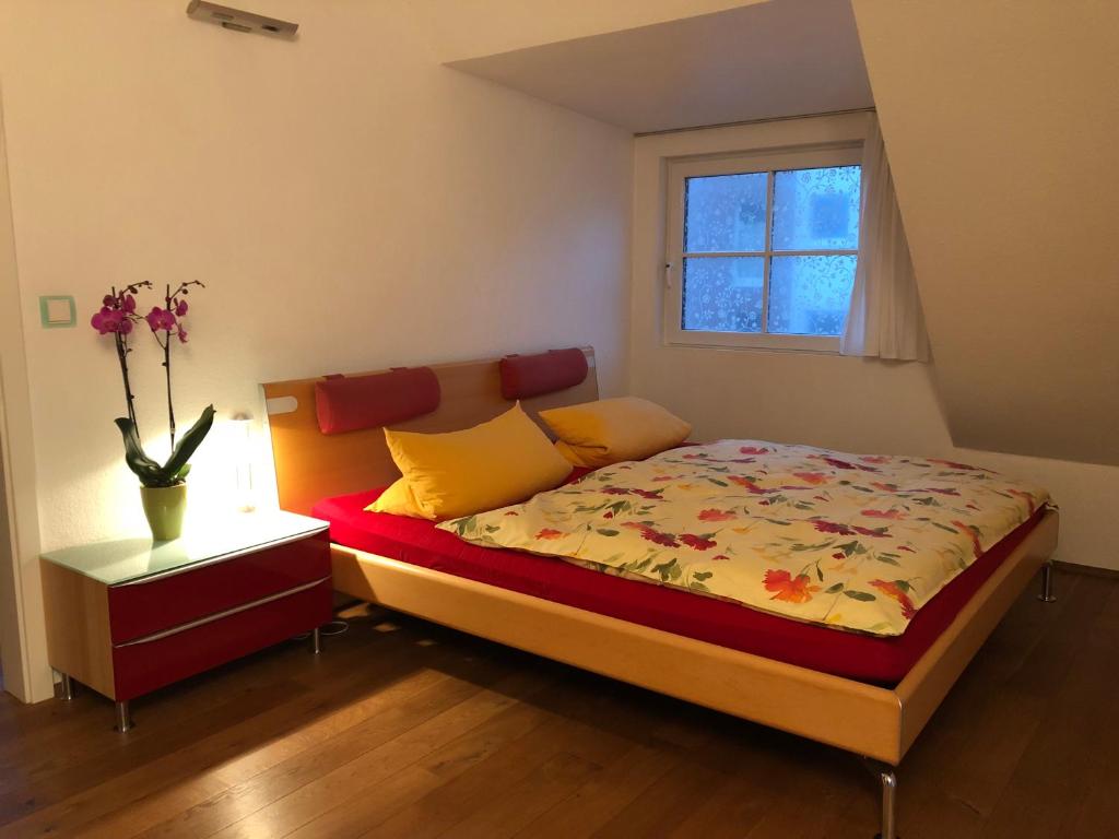 a bedroom with a bed and a vase with flowers on it at Moderne Wohnung 15min International Airport Messe DÜS in Willich