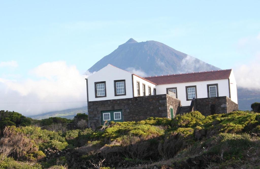 a house on a hill with a mountain in the background at Dream By The Sea in Madalena