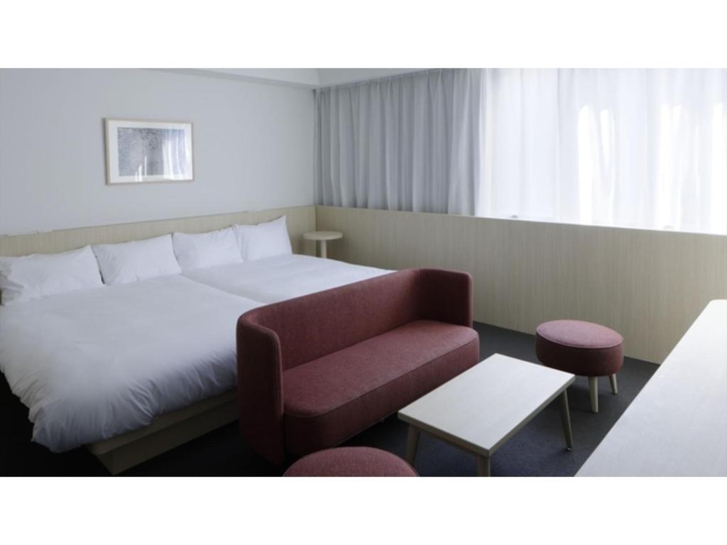 a hotel room with a bed and a red couch at SOKI KANAZAWA - Vacation STAY 40338v in Kanazawa