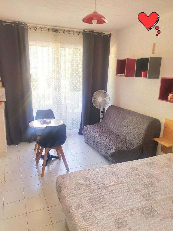 une chambre avec un lit, une table et un bureau dans l'établissement coquet Studio Classé Deux Étoiles, Balcon avec Table, et Wifi, à Gréoux-les-Bains