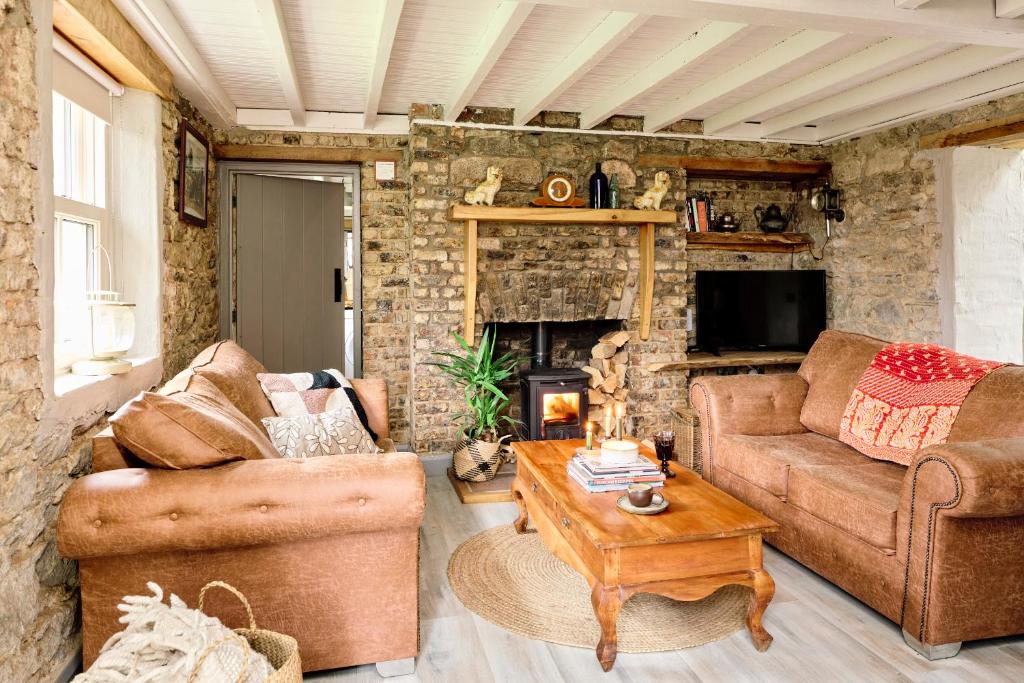 a living room with two couches and a fireplace at Kilquiggan Cottages in Coolkenna Street