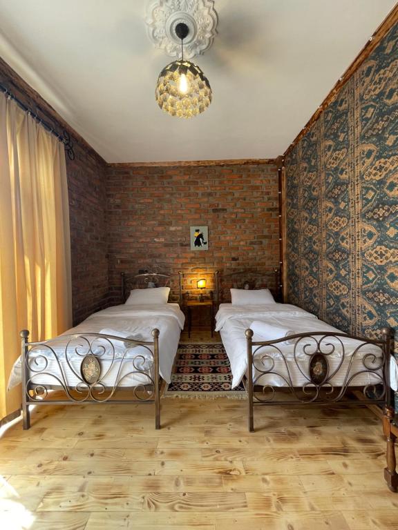 a bedroom with two beds and a chandelier at Odo’s Guest House in Martvili