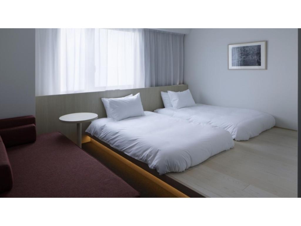 金沢市にあるSOKI KANAZAWA - Vacation STAY 40307vのベッド2台とテーブルが備わる客室です。
